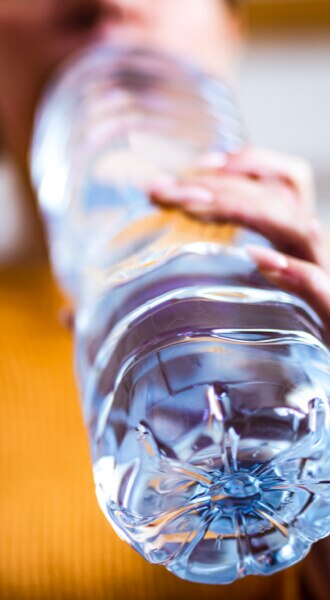 Plastikflasche, die Mann in der Hand hält und daraus trinkt - Homme tenant une bouteille en plastique et buvant à cette derni