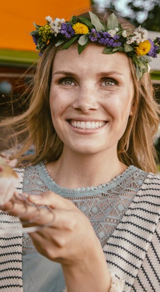 Frau mit einem Muffin Blech und Blumen im Haar mobile