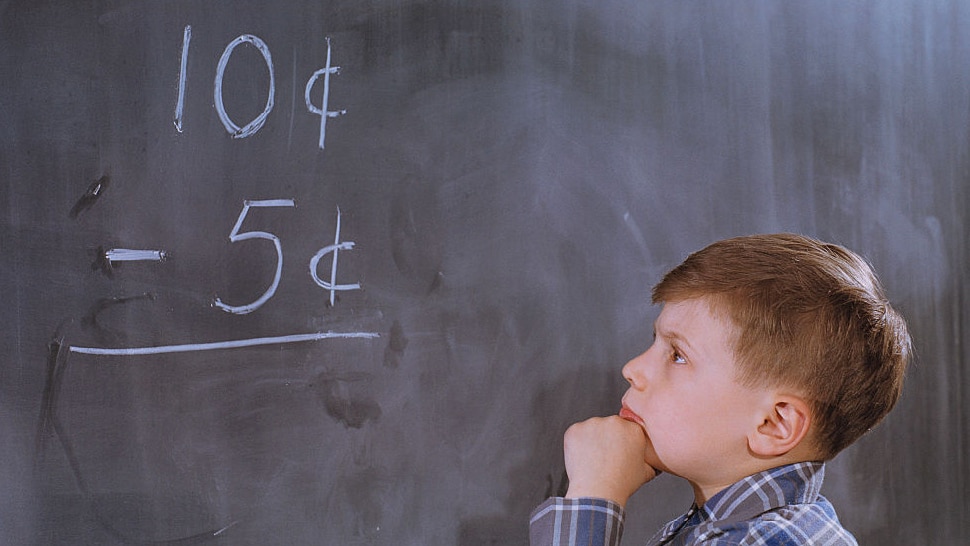 Junge rechnet vor Tafel