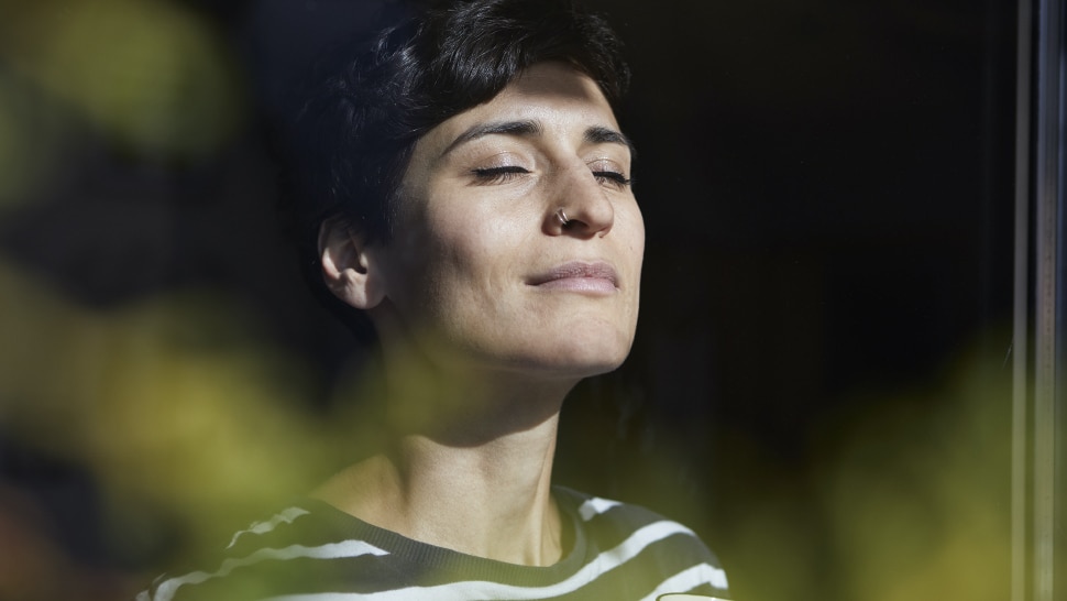 Frau atmet am Morgen mit einem Kaffee tief ein - Une femme prend une profonde inspiration le matin avec un café.