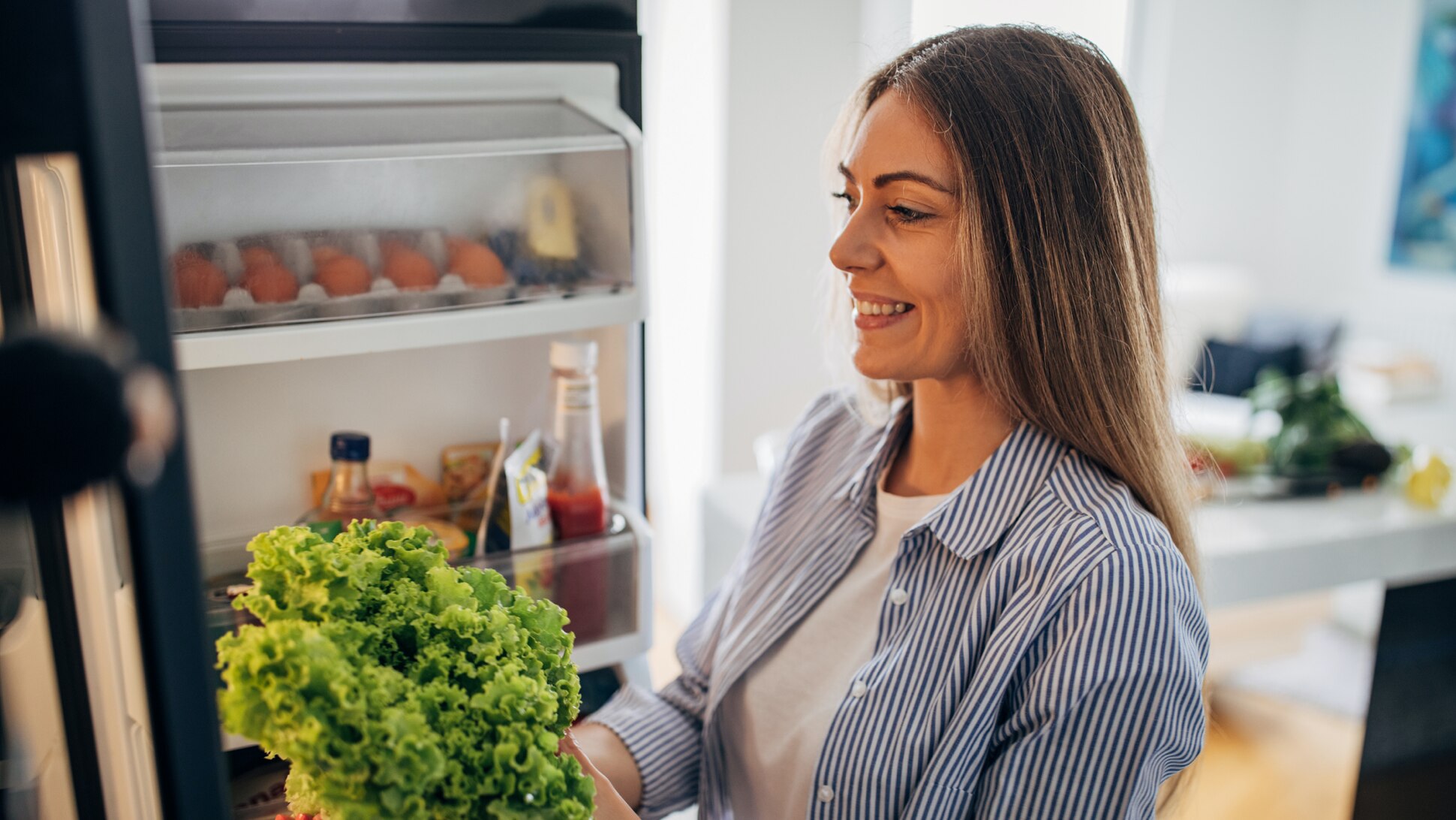 Frau in der Küche am Kühlschrank