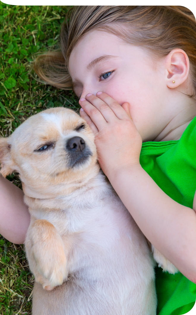 Kind mit Hund auf einer Wiese