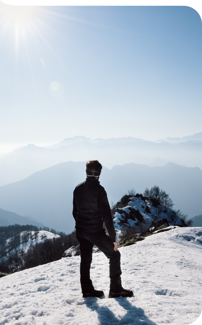 Mann schaut bei Schnee in die Ferne