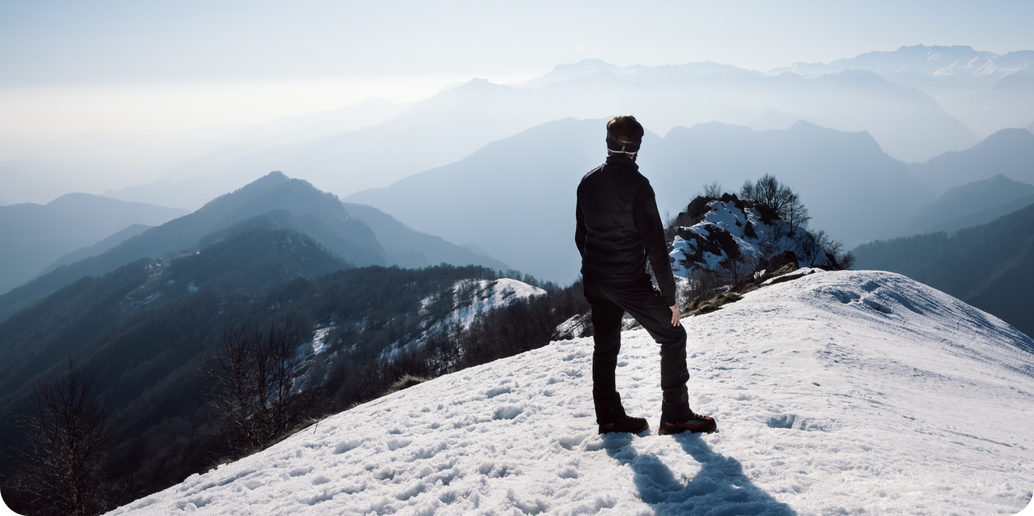 Mann schaut bei Schnee in die Ferne