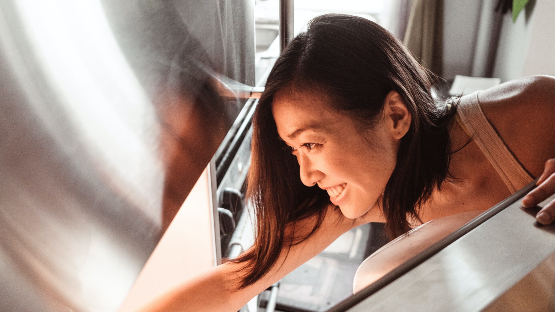 Frau schaut in Kühlschrank