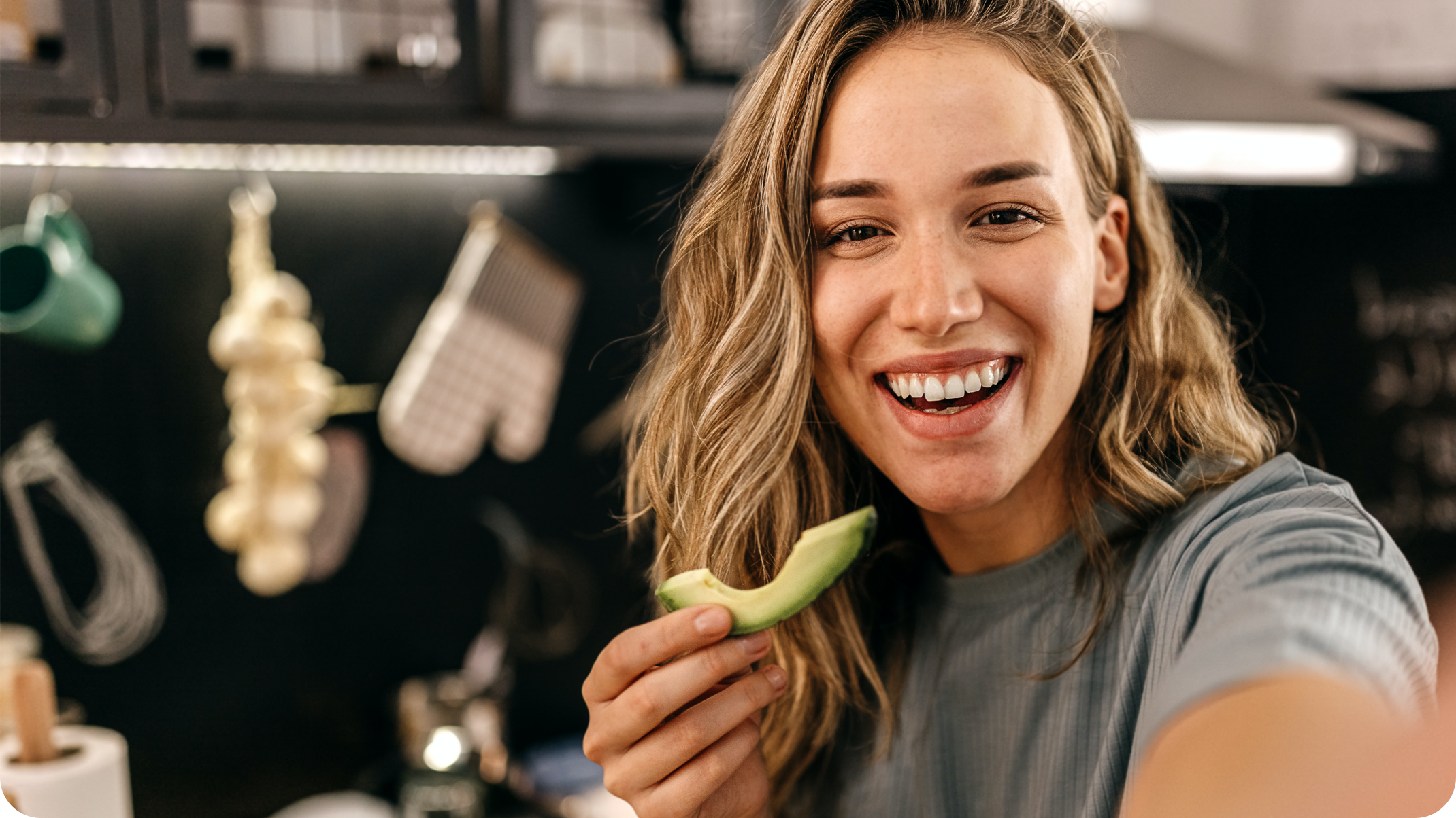 Frau mit Avocado in der Hand