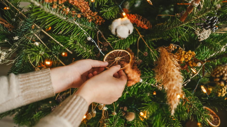 une femme décore un arbre de Noël