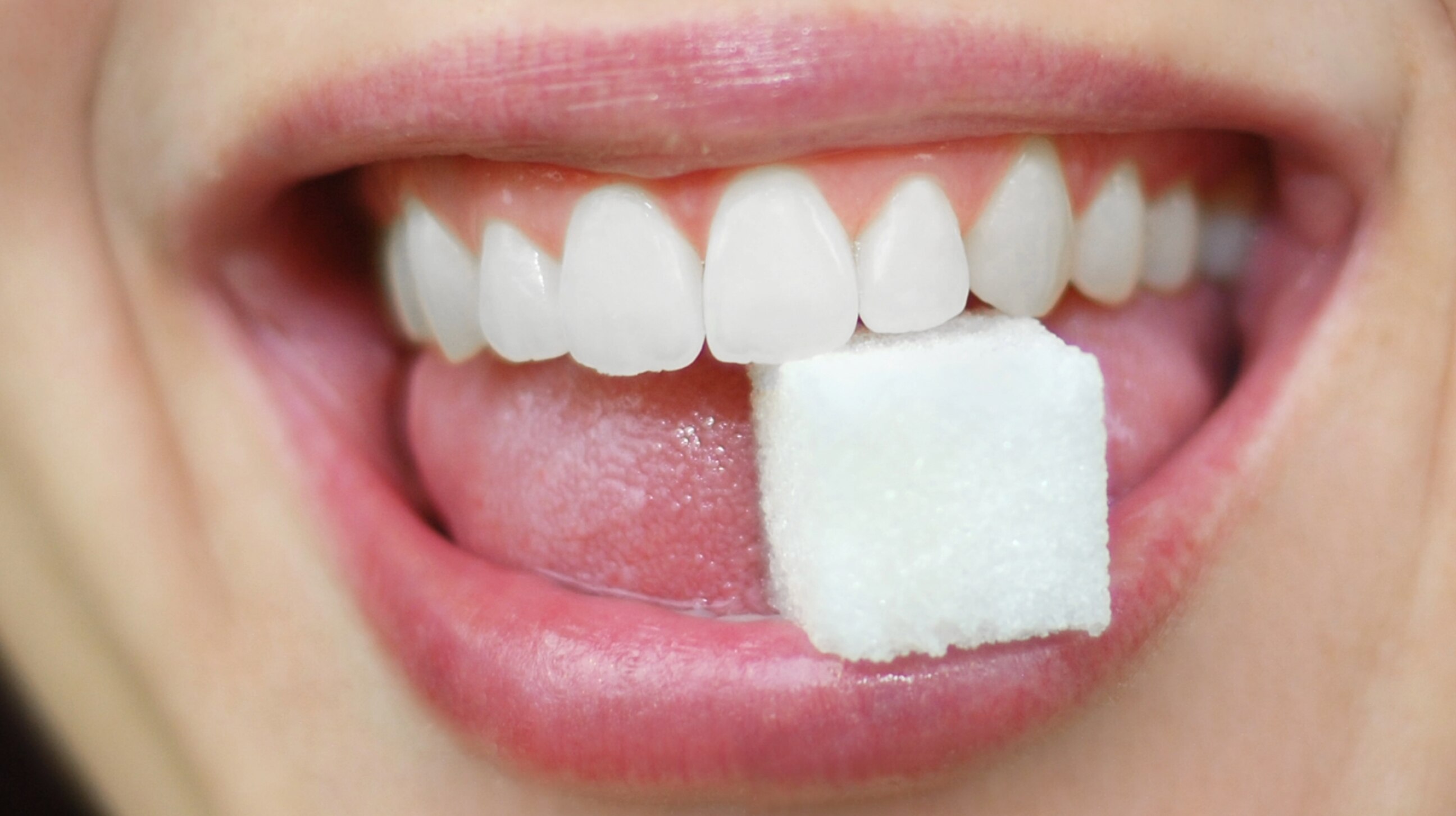 femme avec un morceau de sucre dans la bouche