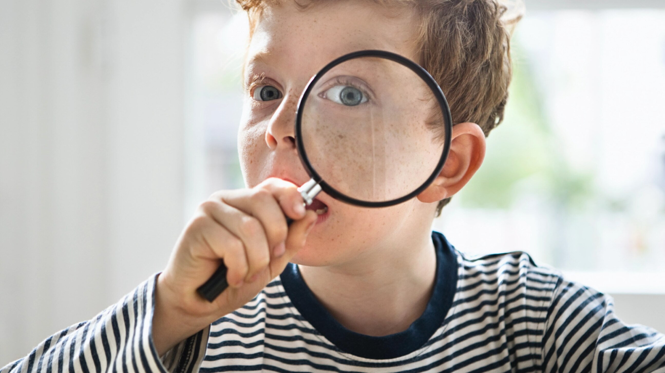 un enfant regarde à travers une loupe