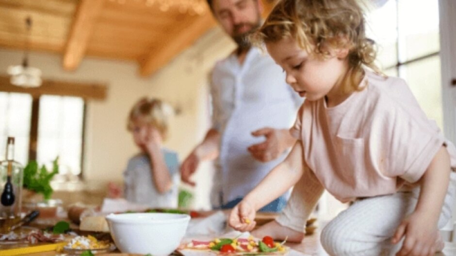 Deux enfants et leur père cuisinent ensemble