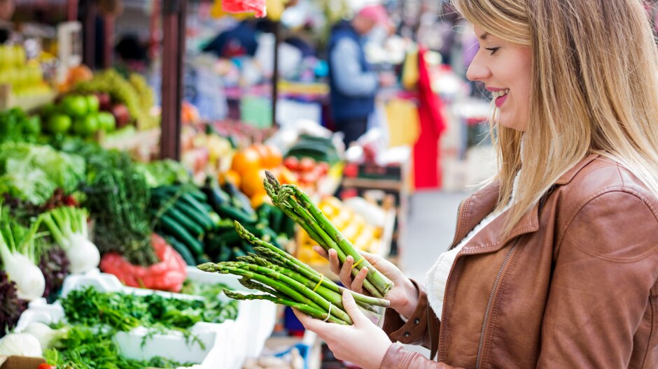 Une femme achète des légumes au marché