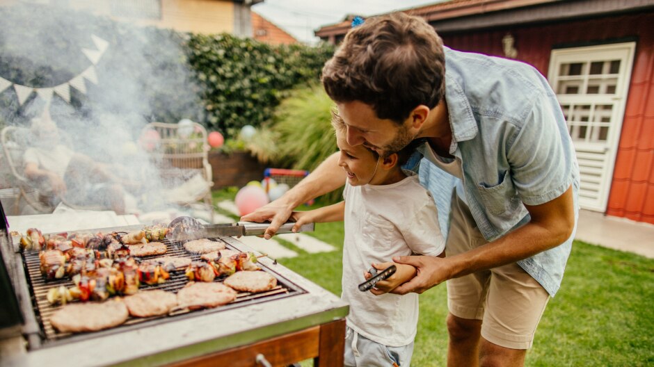 Pere et fils preparent des grillades