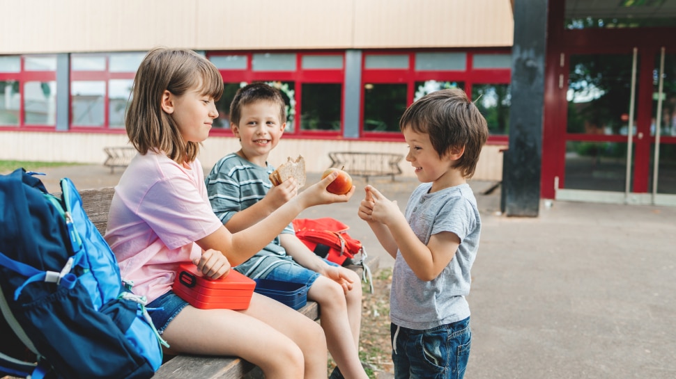 Kinder teilen Snacks im Pausenhof