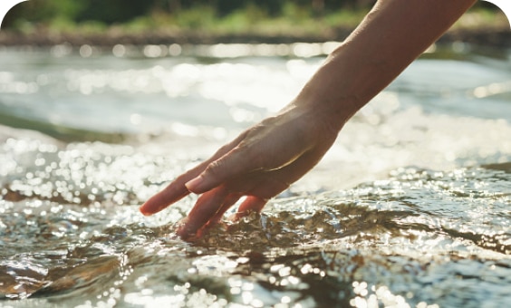 eine-hand-berührt-das-wasser-eines-flusses