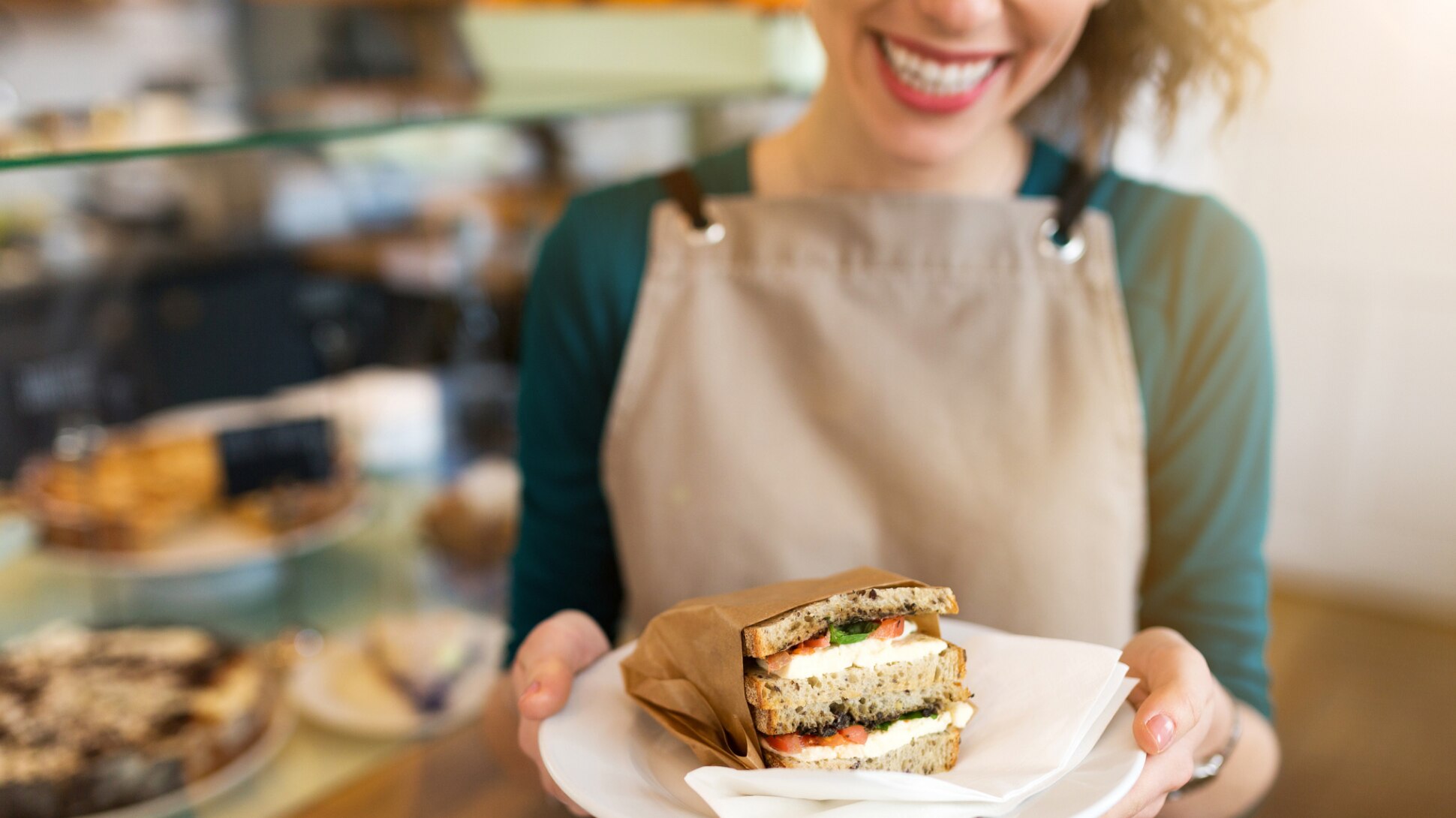 Eine Kellnerin serviert ein Sandwich