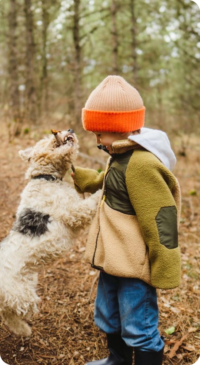 Enfant jouant avec un chien dans la forêt