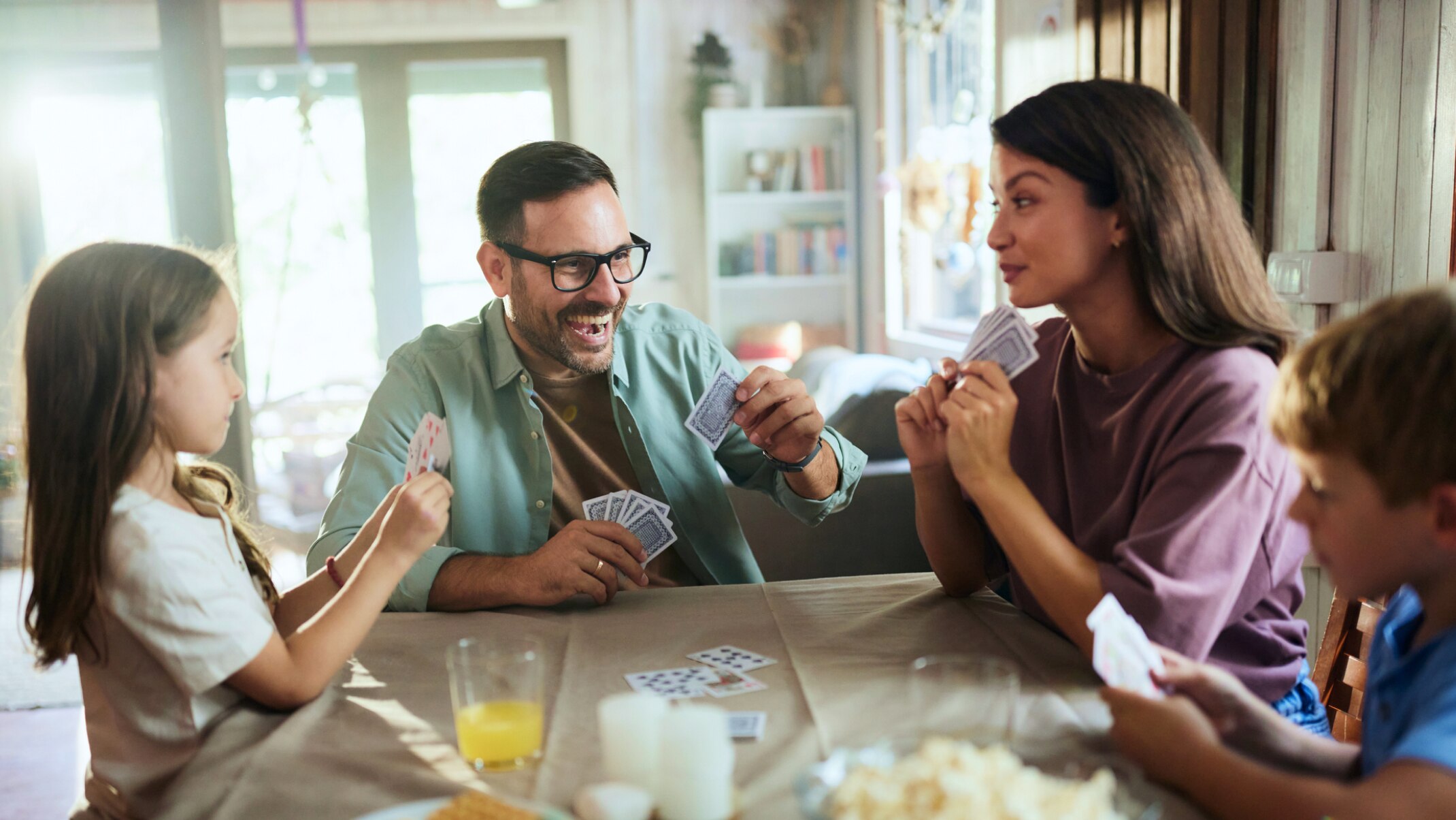 Familie spielt zusammen Karten