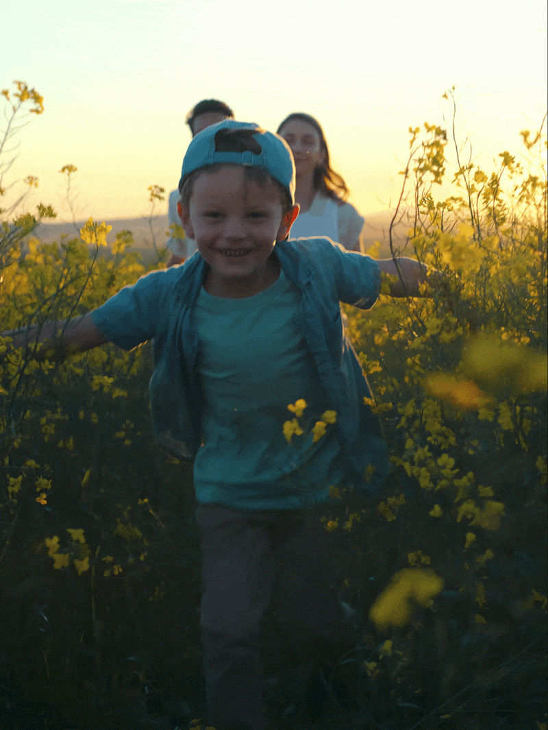 Kind rennt durch ein Blumenfeld 
