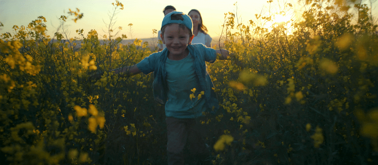 Kind rennt durch ein Blumenfeld 