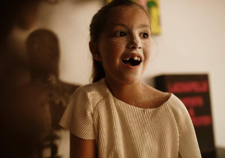 Mädchen mit Mehl im Gesicht