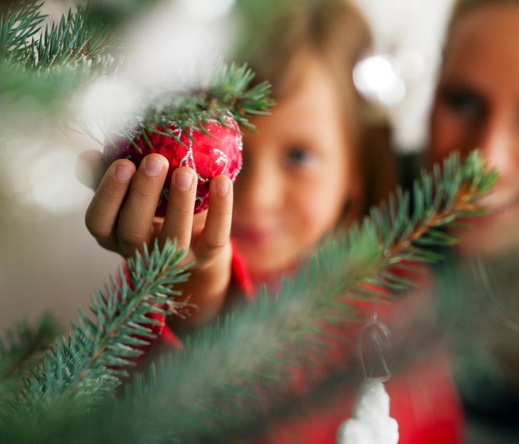 Kind hält Weihnachtskugel