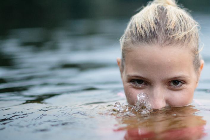 Frau schaut mit dem Kopf aus dem Wasser