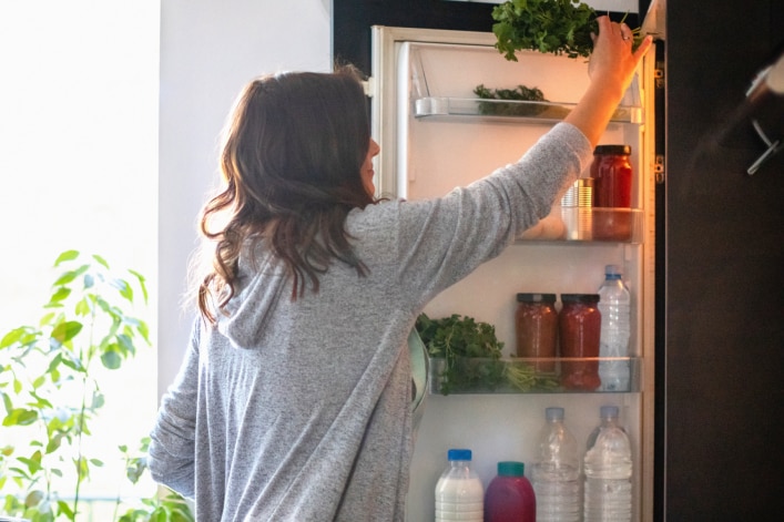 Frau an Kühlschrank