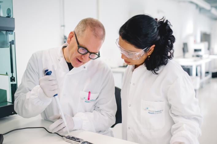 Ein Mann und eine Frau in weissen Laborkitteln testen eine Substanz in einem Nestlé-Labor.