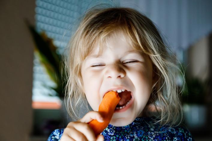 Kind isst eine Karotte
