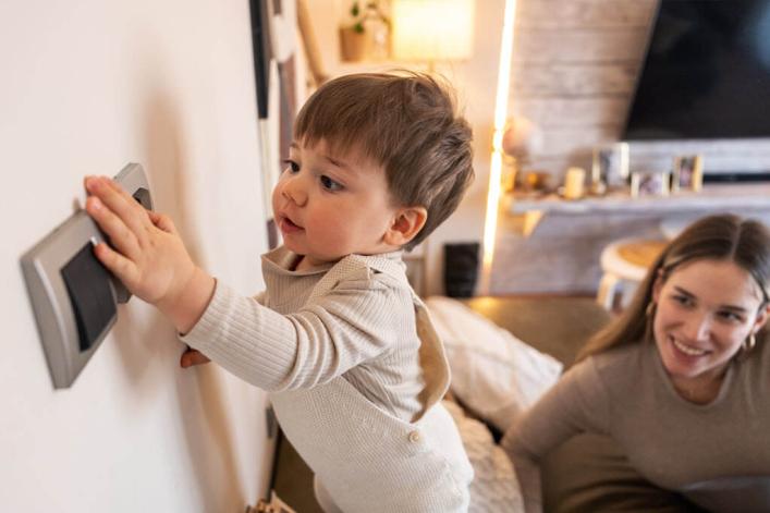Kleines Kind, das den Lichtschalter betätigt