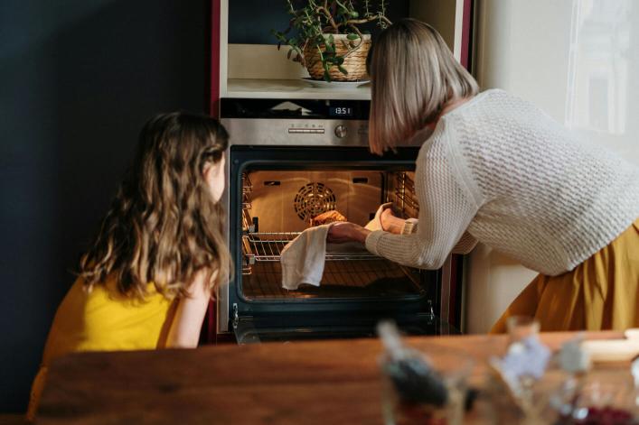 Une fille aide sa mère à cuisiner