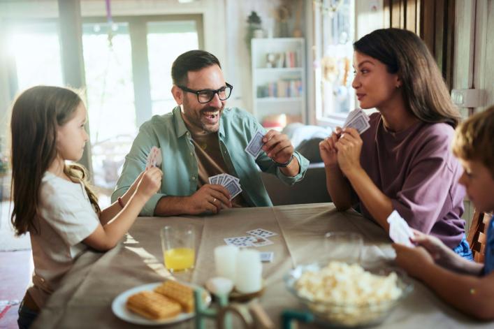 Familie spielt zusammen Karten