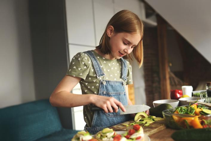 Kind schneidet in der Küche Gemüse