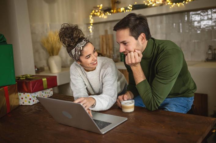 Junges Paar informiert sich auf dem Laptop während der Weihnachtszeit