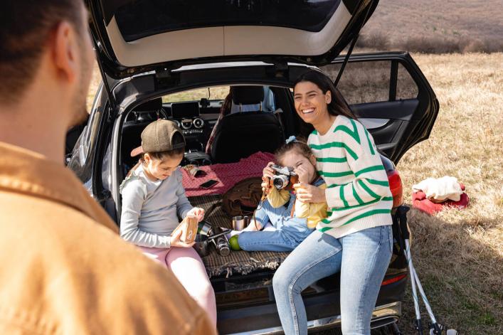Fille prenant en photo son père avec un appareil photo rétro lors de leur pique-nique, capturant un moment de bonheur