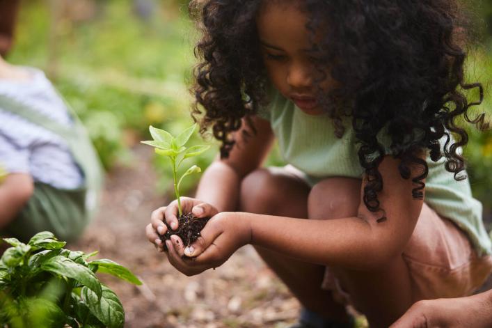 Jeune fille plantant un arbre avec sa famille pour un avenir plus durable