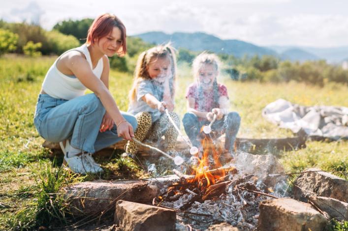 Geschwister grillen an einem Lagerfeuer 