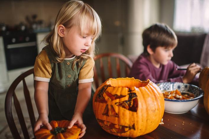Geschnitzter Kürbis auf dem Tisch bei Halloween-Vorbereitung.