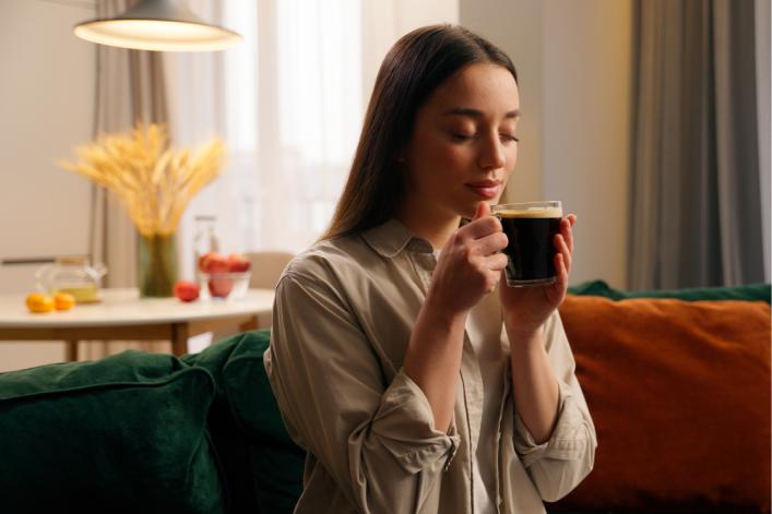 Femme-savourant-un-café-sur-son-fauteuil 