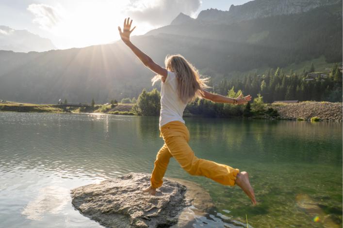 Femme-saute-sur-un-rocher-dans-un-lac