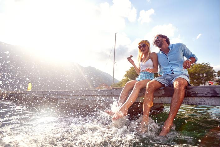 Lachendes Paar sitzt am Wasser 