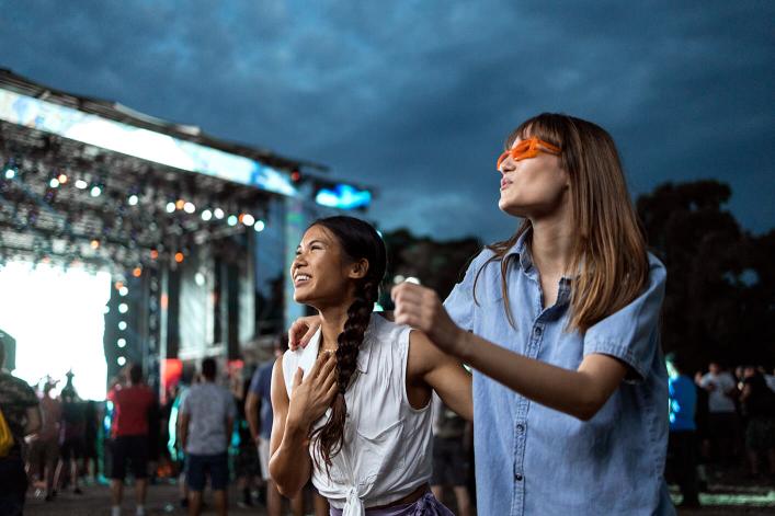 Zwei Mädchen tanzen auf einem Musikfestival.