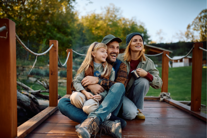 Fröhliche Familie sitzt auf einem Steg 