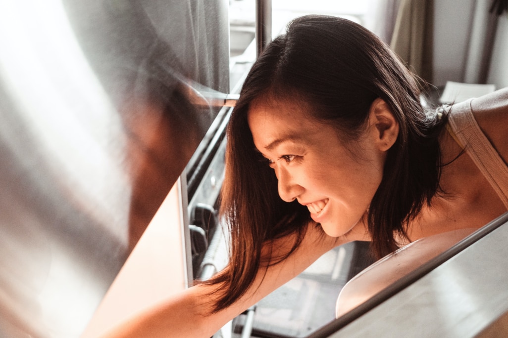 Frau schaut in Kühlschrank