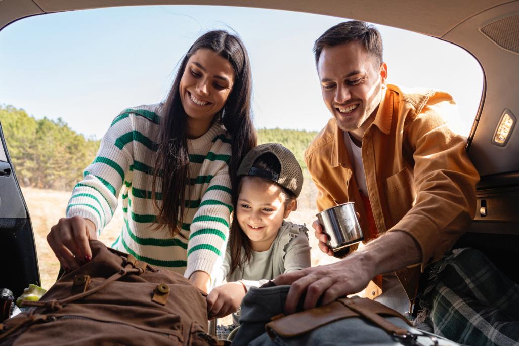 Familie packt Picknick Sachen ins Auto