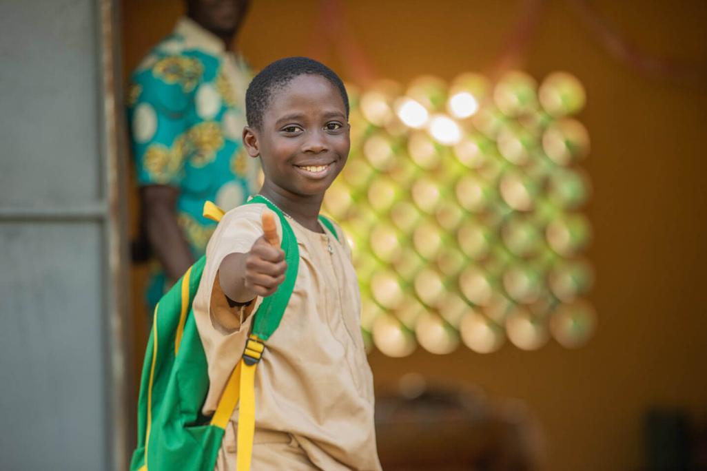 Un garçon souriant lève le pouce pour montrer son contentement