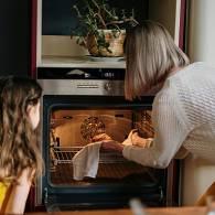  Fille et grand-mère en train d’utiliser un four