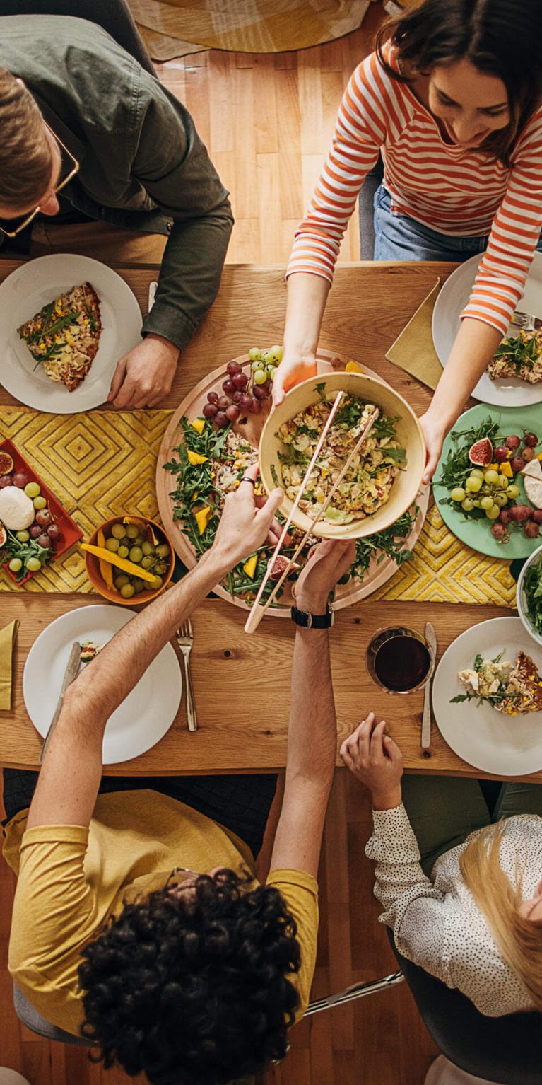 Freunde sitzen gemeinsam am Tisch und geniessen ein leckeres Essen.