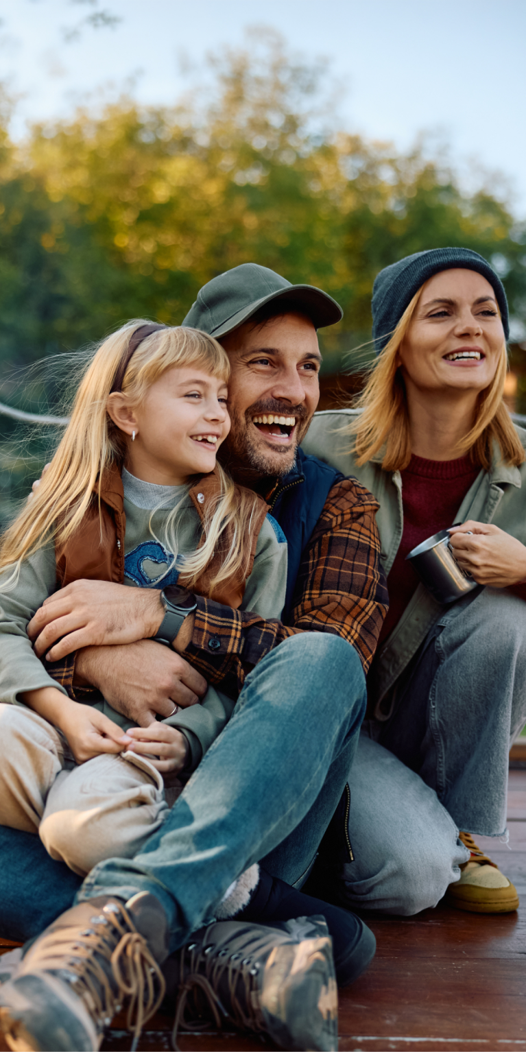 Fröhliche Familie sitzt auf einem Steg