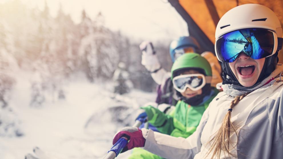 Kinder winken aus dem Skilift